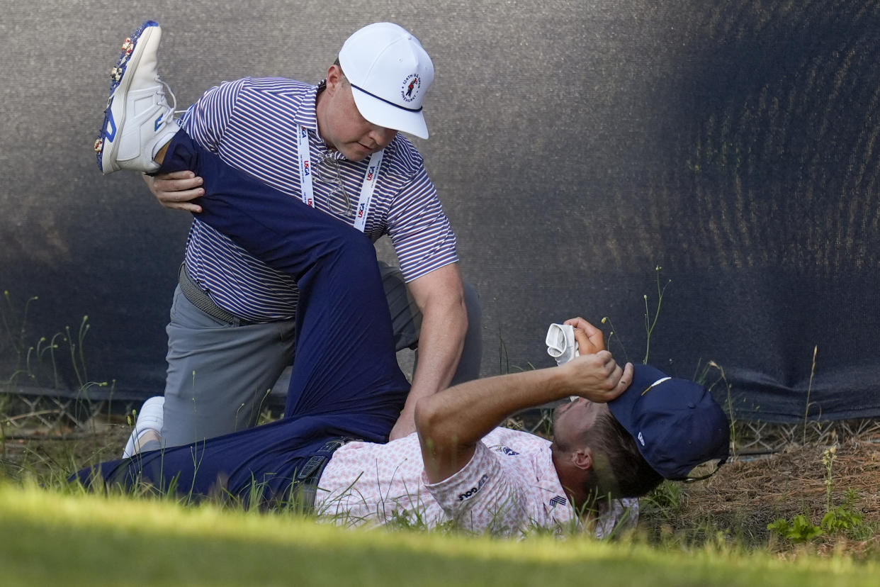Bryson DeChambeau gets treatment on the 11th hole during the third round of the U.S. Open golf tournament Saturday, June 15, 2024, in Pinehurst, N.C. (AP Photo/Mike Stewart)