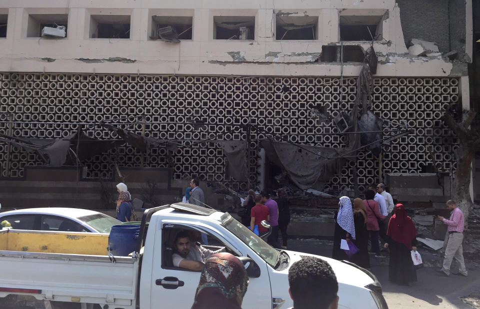 People survey the aftermath of a fiery car crash outside the National Cancer Institute in Cairo, Egypt, Monday, Aug. 5, 2019. The multiple-car crash set off an explosion that ignited a fire at Egypt's main cancer hospital, the government said.(AP Photo/Maya Alleruzzo)