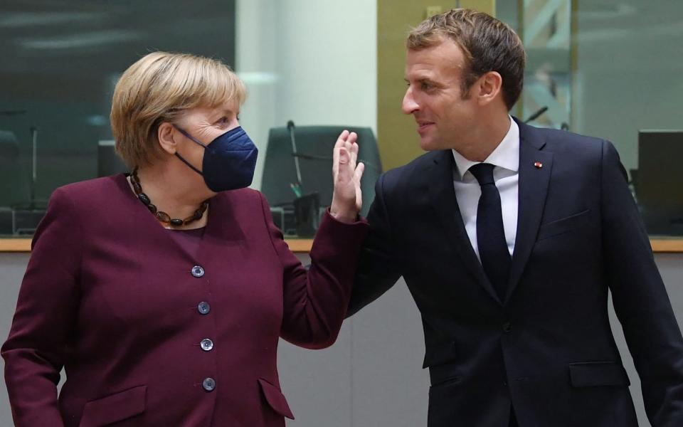 Germany's Chancellor Angela Merkel speaks with France's President Emmanuel Macron on the second day of the EU summit - John Thys/AFP