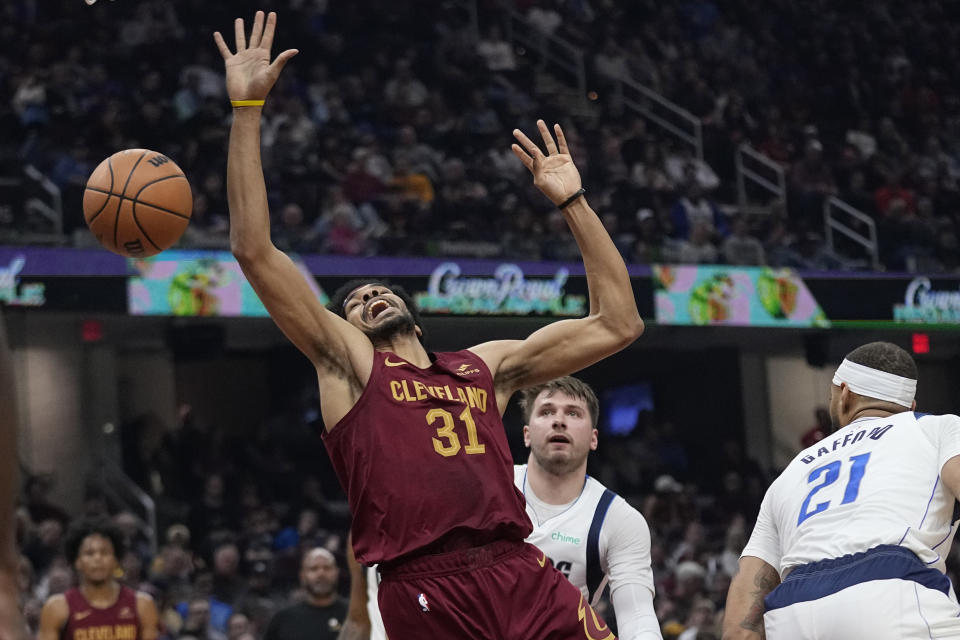 Cleveland Cavaliers center Jarrett Allen (31) loses the ball after a foul by Dallas Mavericks guard Luka Doncic, center, during the first half of an NBA basketball game Tuesday, Feb. 27, 2024, in Cleveland. (AP Photo/Sue Ogrocki)