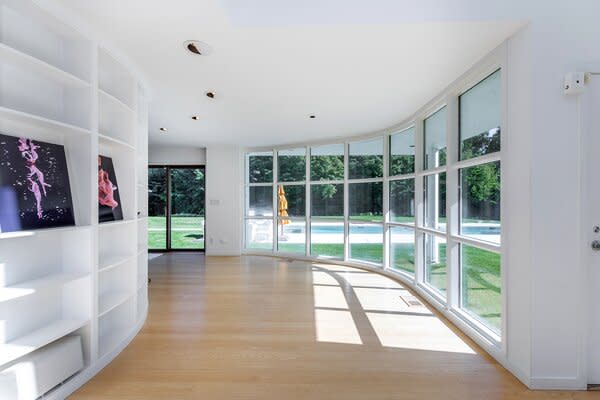 Upon entry, built-in shelving lines the curved wall leading to the main gathering hubs.