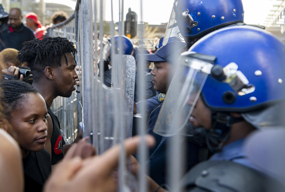 Demonstrators confront police in an attempt to gain entry to where the World Economic Forum on Africa is being held in Cape Town, South Africa, Wednesday, Sept. 4, 2019. The protesters are demanding that the government crack down on gender-based violence, following a week of brutal murders of young South African women that has shaken the nation. (AP Photo)