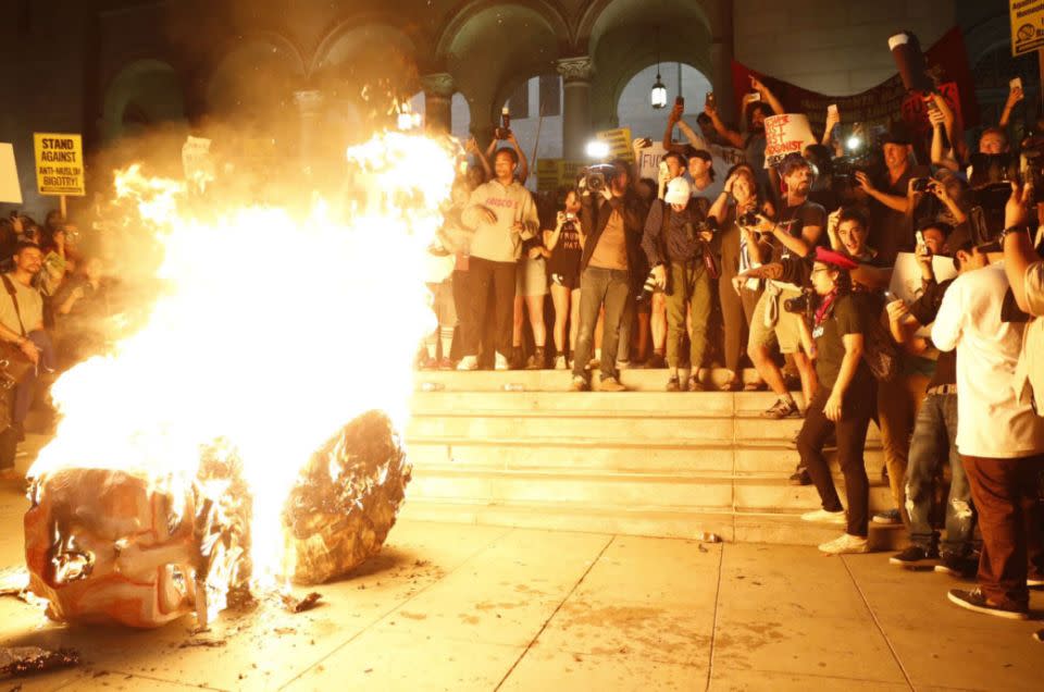 Protestors set a Trump effigy on fire. Photo: Twitter/yamphoto