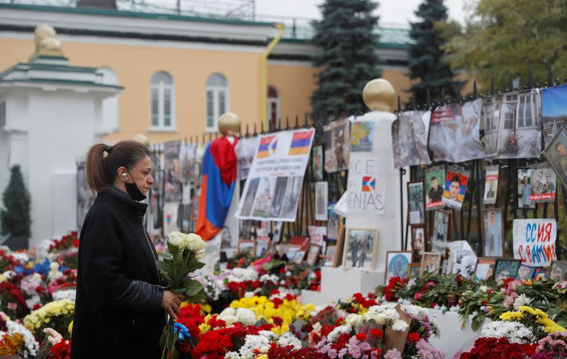 A woman visits a makeshift memorial outside the Armenian embassy for people killed during a military conflict over the breakaway region of Nagorno-Karabakh in Moscow