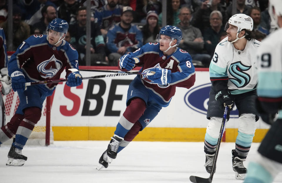 Colorado Avalanche defensemen Cale Makar, center, and Devon Toews, left, break downice with Seattle Kraken left wing Brandon Tanev in pursuit of the puck in the first period of an NHL hockey game Sunday, March 5, 2023, in Denver. (AP Photo/David Zalubowski)