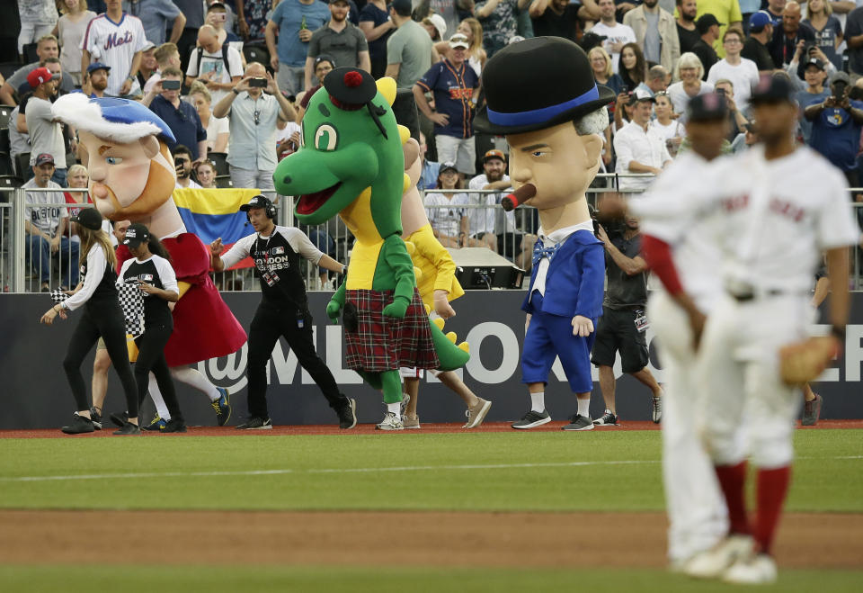 Characters including from left, King Henry VIII, the Loch Ness monster and Winston Churchill participate in a mascot race during a baseball game between the Boston Red Sox and the New York Yankees, Saturday, June 29, 2019, in London. Major League Baseball made its European debut game Saturday at London Stadium. (AP Photo/Tim Ireland)