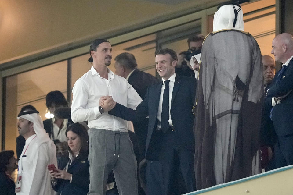 Swedish soccer player Zlatan Ibrahimovic, left, shakes hands with France's President Emmanuel Macron gestures on the tribune ahead of the World Cup final soccer match between Argentina and France at the Lusail Stadium in Lusail, Qatar, Sunday, Dec. 18, 2022. (AP Photo/Martin Meissner)