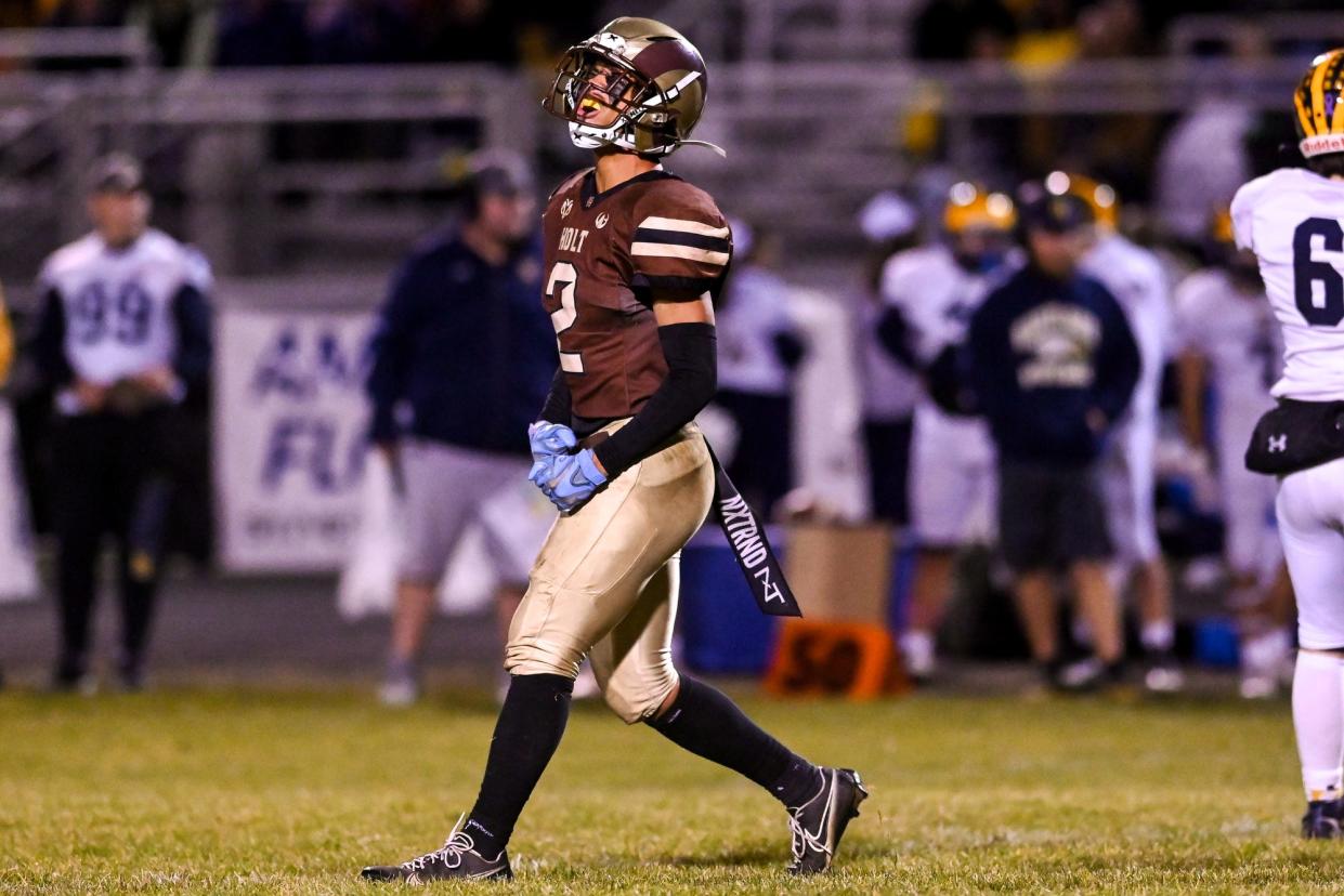 Holt's Isaiah Foster celebrates after a defensive stop against Hartland during the fourth quarter on Friday, Oct. 28, 2022, at Holt High School.