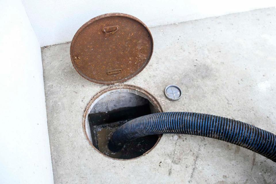 A close up of a black pipe in a sewer.