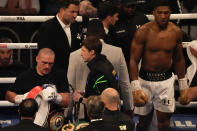 Oleksandr Usyk of Ukraine examines his winner's belts after his unanimous decision over Anthony Joshua of Britain in their WBA (Super), WBO and IBF boxing title bout at the Tottenham Hotspur Stadium in London, Saturday, Sept. 25, 2021. (AP Photo/Frank Augstein)