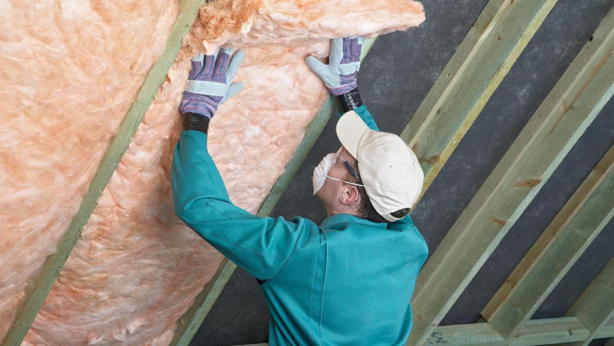 A worker installing insulation