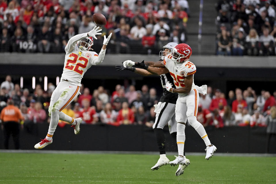 Kansas City Chiefs safety Juan Thornhill (22) intercepts a pass intended for Las Vegas Raiders wide receiver Mack Hollins as Chiefs cornerback Jaylen Watson (35) watches during the first half of an NFL football game Saturday, Jan. 7, 2023, in Las Vegas. (AP Photo/David Becker)