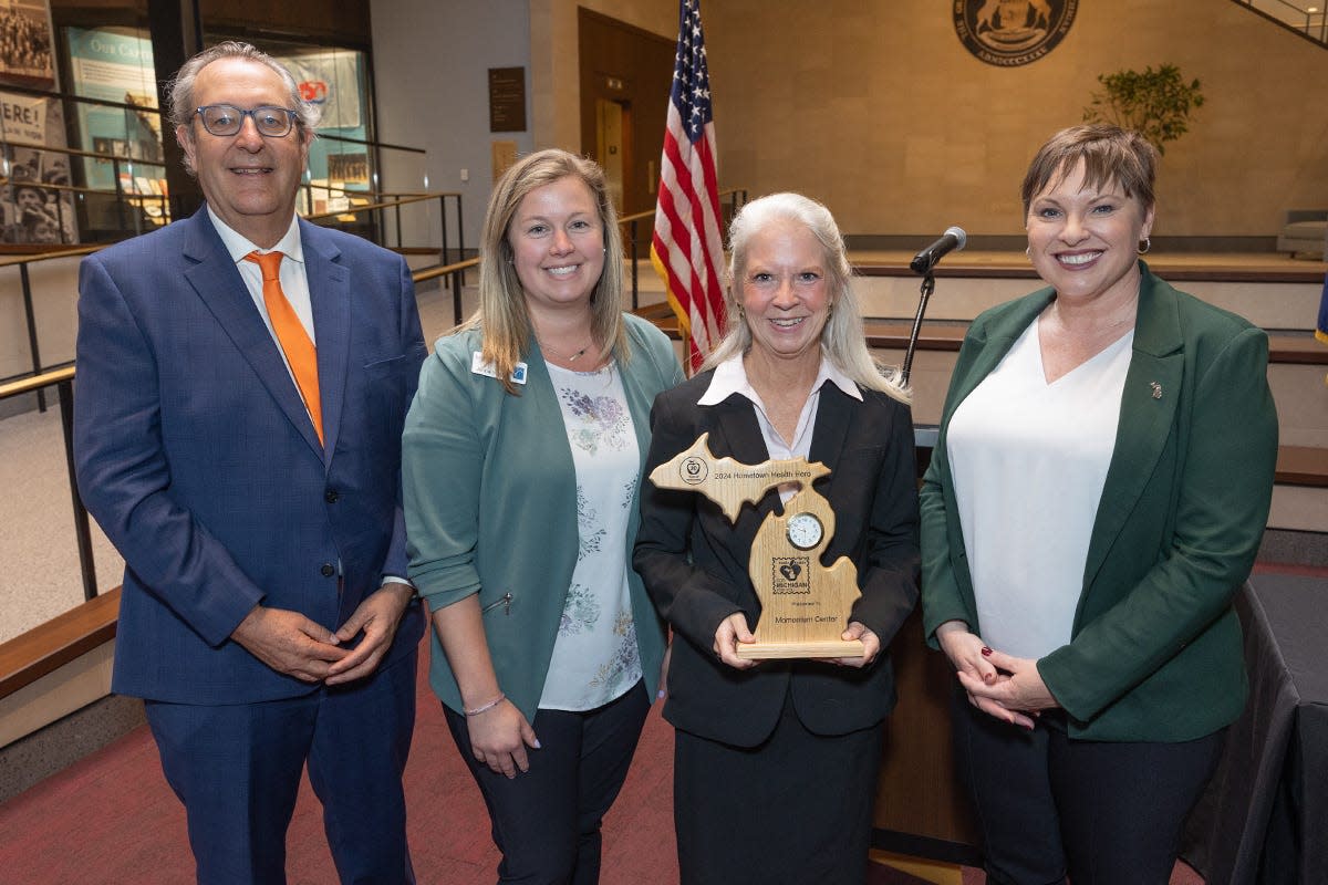 Jenna Vipond (middle left) and Barbara Lee VanHorssen (middle right) stand with State Sen. Roger Victory and MDHHS Director Elizabeth Hertel after the Momentum Center was given a 2024 Hometown Health Hero Award.