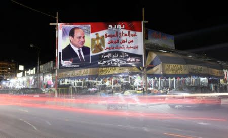 A banner supporting President Abdel Fattah al-Sisi's re-election hangs at a clothes market near the canal of Port Said, Egypt March 18, 2018. REUTERS/Mohamed Abd El Ghany