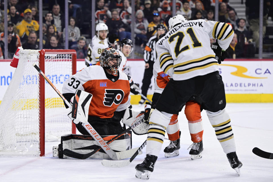 Philadelphia Flyers goaltender Samuel Ersson, left, looks for a loose puck past Boston Bruins' James van Riemsdyk (21) during the first period of an NHL hockey game, Saturday, Jan. 27, 2024, in Philadelphia. (AP Photo/Derik Hamilton)