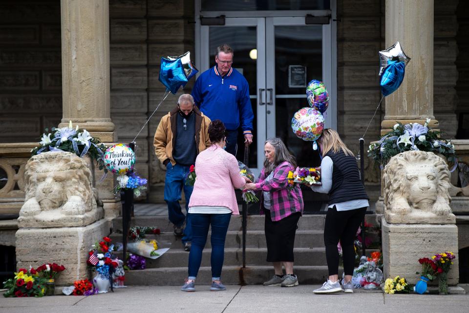 Community members place flowers and balloons outside of the main entrance to the Anamosa State Prison, on Wednesday, March 24, 2021, a day after a nurse and correctional officer were killed while on duty, in Anamosa, Iowa. 