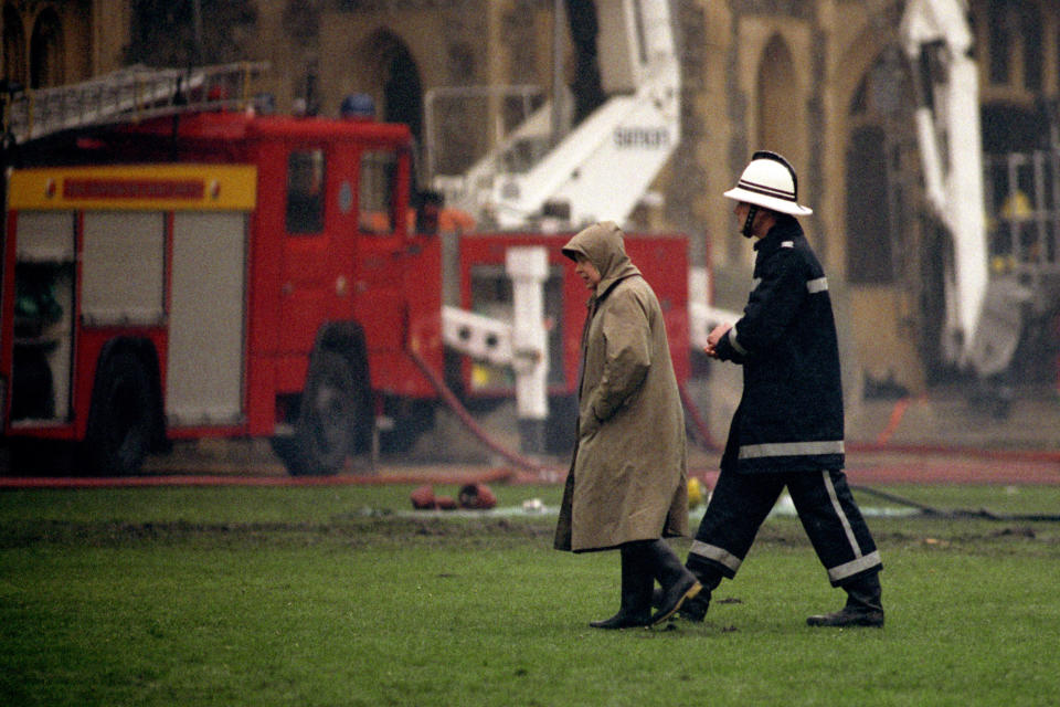 <p>The Queen and a firefighter survey the scene on 21 November 1992 after a blaze at Windsor Castle the previous day. (PA)</p> 