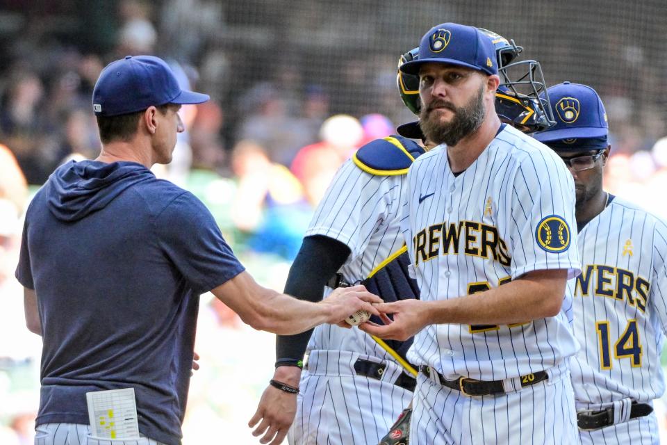 Sep 3, 2023; Milwaukee, Wisconsin, USA; Milwaukee Brewers pitcher Wade Miley (20) hands the ball to manager Craig Counsell during a pitching change in the seventh inning against the Philadelphia Phillies at American Family Field. Mandatory Credit: Benny Sieu-USA TODAY Sports