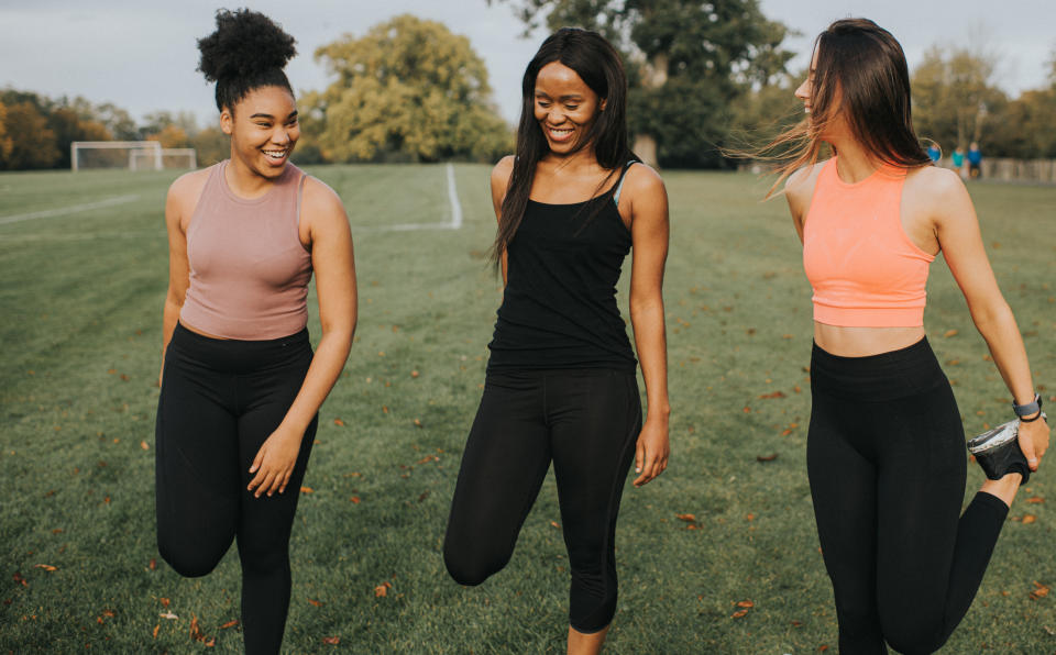 Three friends enjoying a walk together on a soccer field