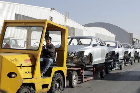 A worker transports car chassis at the Volkswagen plant in Puebla March 9, 2015. REUTERS/Imelda Medina