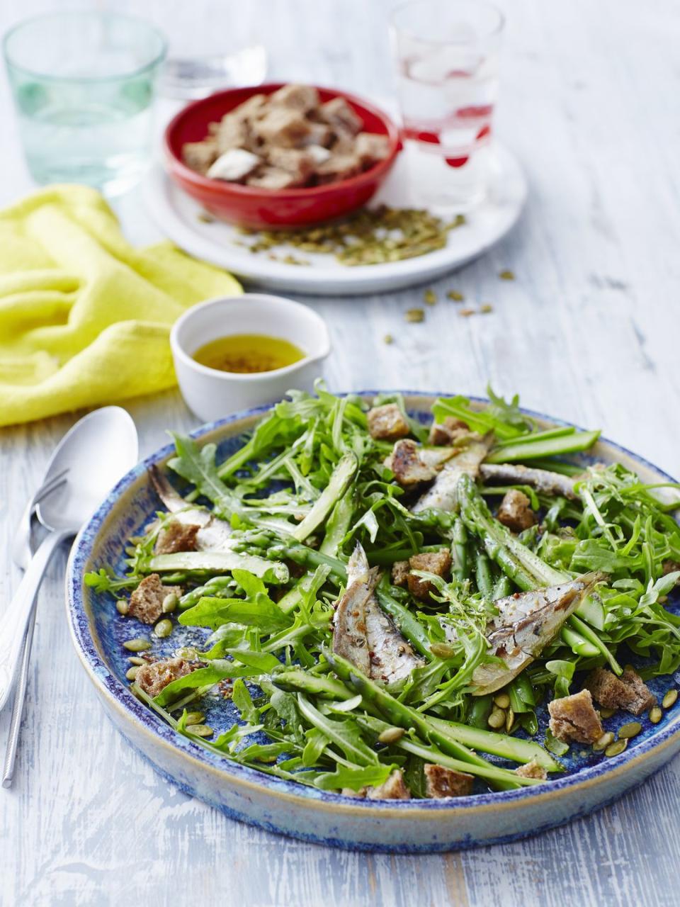 sardines and salad greens on a blue plate