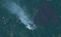 A plume of smoke rises from wildfires near Kharbalakh, Russia