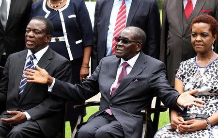 FILE PHOTO: Zimbabwe's President Robert Mugabe (C) sits with his wife Grace Mugabe and Emmerson Mnangagwa (L), who was sworn in as Zimbabwe's vice president, at the State House in Harare, December 12, 2014. REUTERS/Philimon Bulawayo/File Photo
