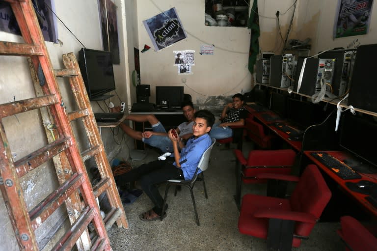 Palestinian refugees sit near computers at the Al-Shati refugee camp, in Gaza City on September 1, 2018