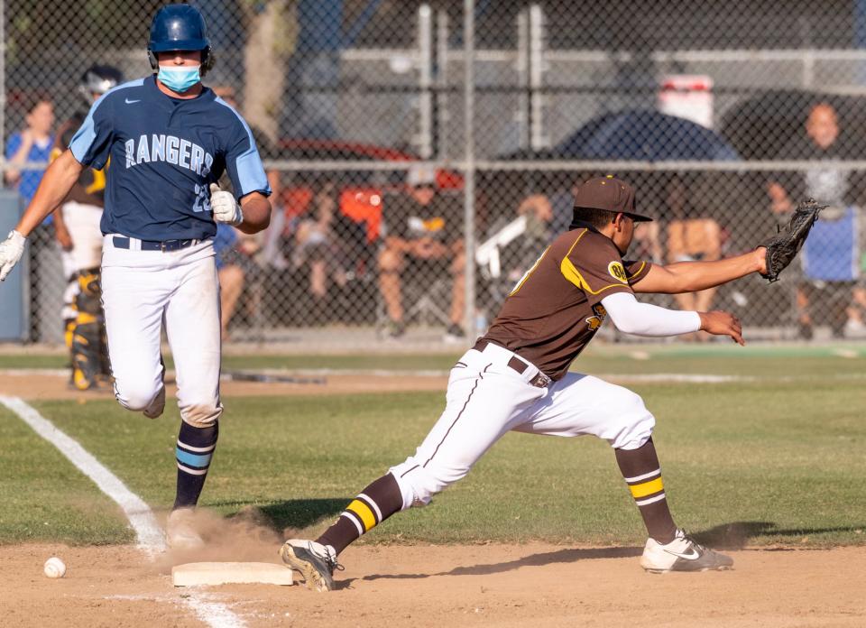 Redwood’s Joey Volchko gets to first as the throw gets past Golden West's Jonathon Ortega in a West Yosemite League high school baseball game on Wednesday, April 21, 2021.