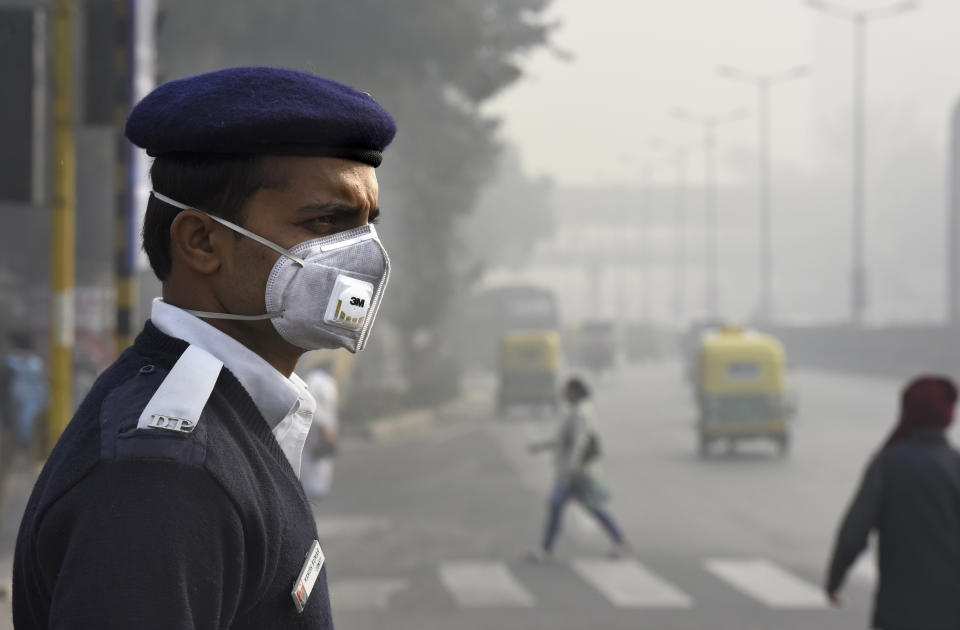 A traffic policeman wears a mask on the road in New Delhi on Jan. 4, 2016.