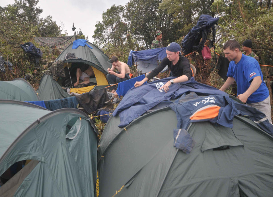 Russian rescuers dry clothes on their tents near the site where a Sukhoi Superjet-100 crashed, on the peak of Mount Salak, West Java, Indonesia, Tuesday, May 15, 2012. Joint teams of Indonesian and Russian experts continued to comb through debris at the bottom of a 1,500-foot (500-meter) ravine on Tuesday afternoon to find the black box of the new passenger jet with 45 people on board that slammed into a cliff atop the dormant Indonesian volcano last week. (AP Photo/Jefri Tarigan)