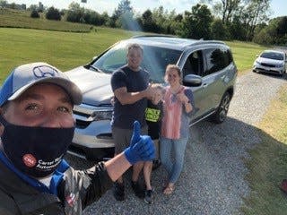 Sales associate Brett West from Carter Myers Automotive’s Valley Honda in Staunton, Virginia delivers a new 2020 Honda Pilot to Jonathan Winingham at his home in Cartersville, Virginia on May 14, 2020.