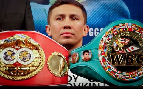 Gennady Golovkin sits behind two of his four championship belts - Credit: AP