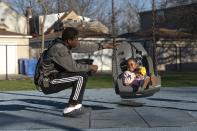 Theon Davis, 21, plays with his 2-year-old daughter Harmony Davis at a park near their home Wednesday, April 12, 2023, in Chicago. One of the nation's top amateur boxers in his his weight class, Davis is on a path he envisions taking him from the rough West Side of Chicago to the Olympics and a professional career. Above all, he wants to provide for Harmony and buy his mom a house. "I was born to do this," he said. "For me, it's just something I'm supposed to do." (AP Photo/Erin Hooley)