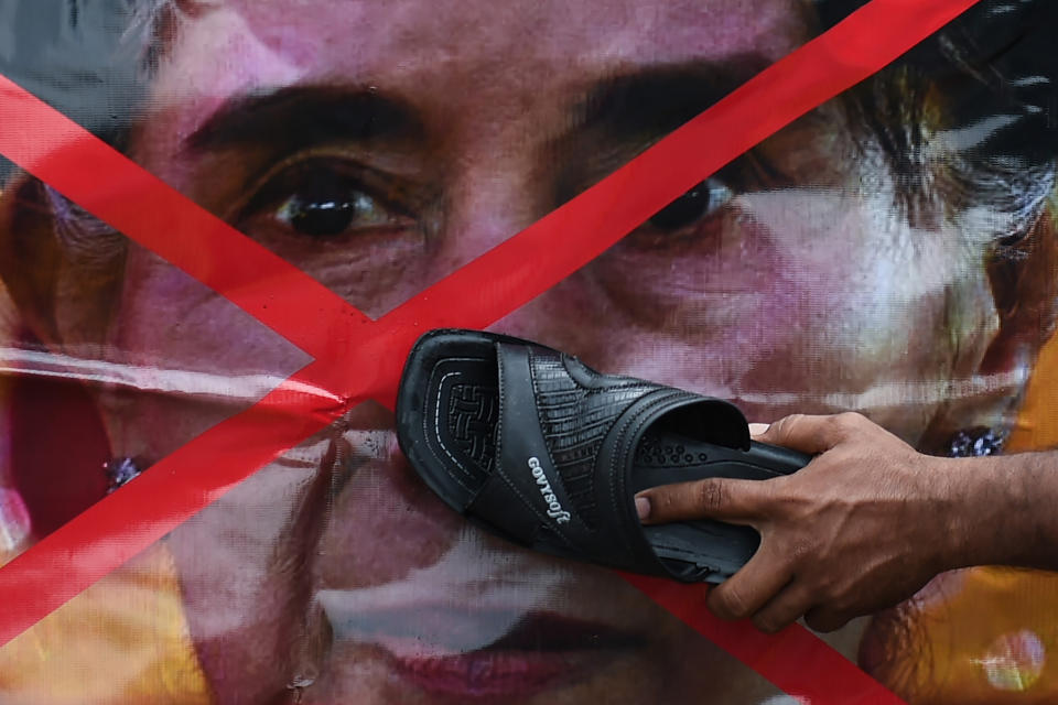 <p>A Rohingya refugee living in Malaysia uses a slipper to hit a banner with a portrait of Myanmar’s State Counselor Aung San Suu Kyi during a protest against the treatment of Rohingya Muslims in Myanmar, in Kuala Lumpur, Malaysia on Sept. 8, 2017. (Photo: Mohd Rasfan/AFP/Getty Images) </p>