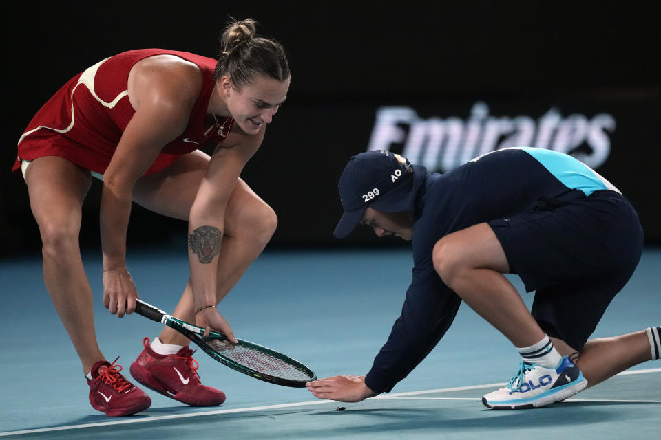 Aryna Sabalenka of Belarus helps a ball kid catch an insect during her quarterfinal against Barbora Krejcikova of the Czech Republic at the Australian Open tennis championships at Melbourne Park, Melbourne, Australia, Tuesday, Jan. 23, 2024. (AP Photo/Louise Delmotte)