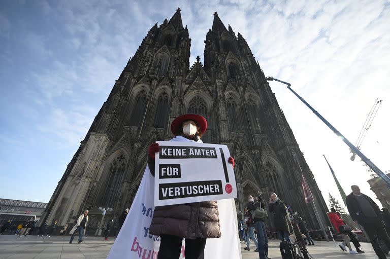 Un participante en un acto de la iniciativa Maria 2.0 sostiene un cartel con la leyenda "nada de oficinas para los encubridores" frente a la catedral de Colonia, Alemania (Archivo)