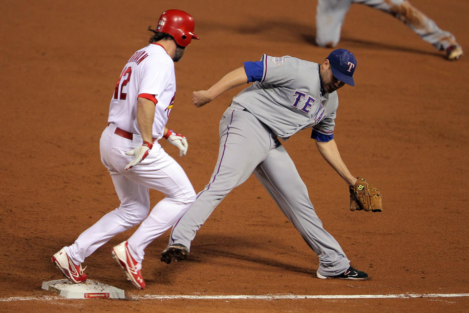 ST LOUIS, MO - OCTOBER 27: Lance Berkman #12 of the St. Louis Cardinals is safe at first base ahead of Colby Lewis #48 of the Texas Rangers after an error by Michael Young #10 in the fourth inning during Game Six of the MLB World Series at Busch Stadium on October 27, 2011 in St Louis, Missouri. (Photo by Doug Pensinger/Getty Images)