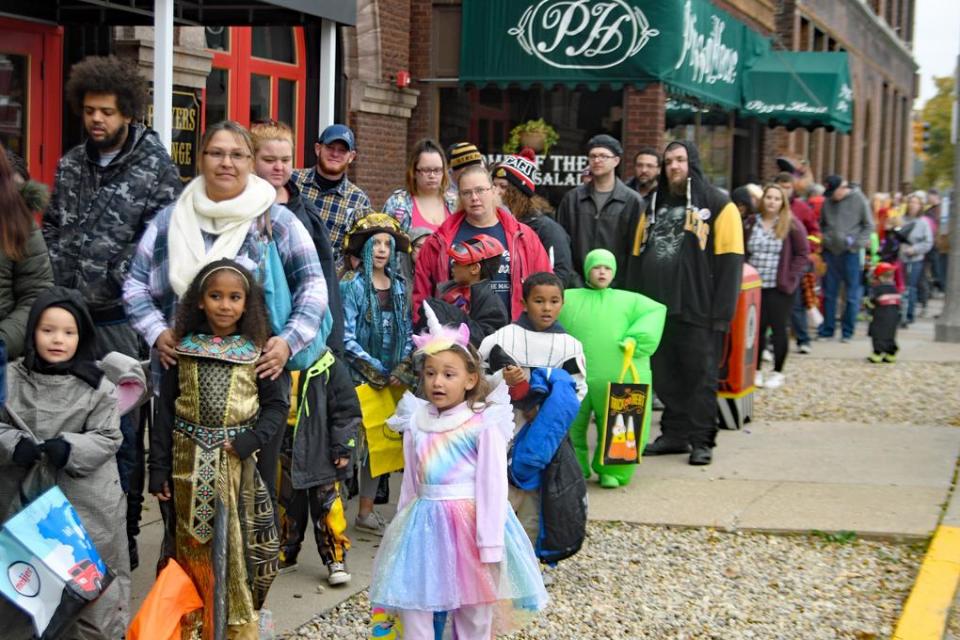 Kids dressed in their costumes wait in line to receive treat bags for Galesburg's 2019 Treat Street.