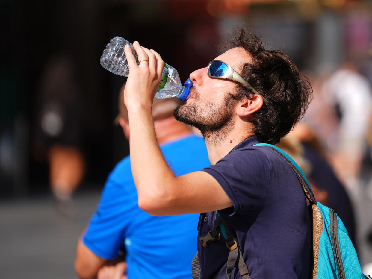 A man drinks a bottle of water on Monday, the hottest day of the year so far. (PA)