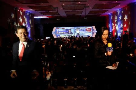 A screen with a broadcast of the U.S. presidential race between Democratic nominee Hillary Clinton and Republican nominee Donald Trump is seen behind TV presenters in a restaurant in Mexico City, Mexico November 8, 2016. REUTERS/Carlos Jasso