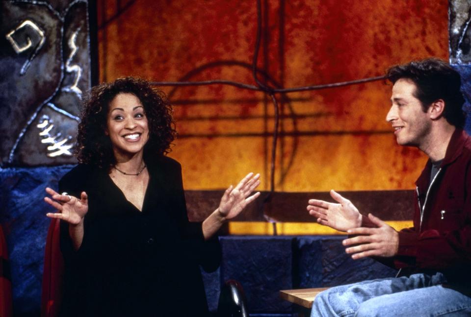 Two people engaged in conversation on a TV show set