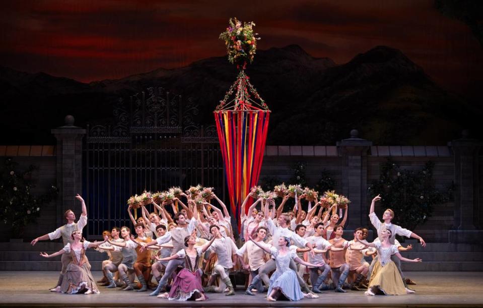 Los bailarines de Miami City Ballet, ubicados alrededor del poste con cintas multicolores, en la primera escena del primer acto de “El Lago de los Cisnes” de Alexei Ratmansky. 