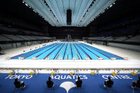 FILE - In this April 26, 2021, file photo, Tokyo 2020 Olympic Games Organizing staff prepare a Paralympic swimming test event at the Tokyo Aquatics Center, one of the venues of the Tokyo 2020 Olympic and Paralympic Games, in Tokyo. Public sentiment in Japan has been generally opposed to holding the Tokyo Olympics and Paralympics. This is partly based of fears the coronavirus will spike as almost 100,000 people — athletes and others — enter for both events.(AP Photo/Eugene Hoshiko, File)