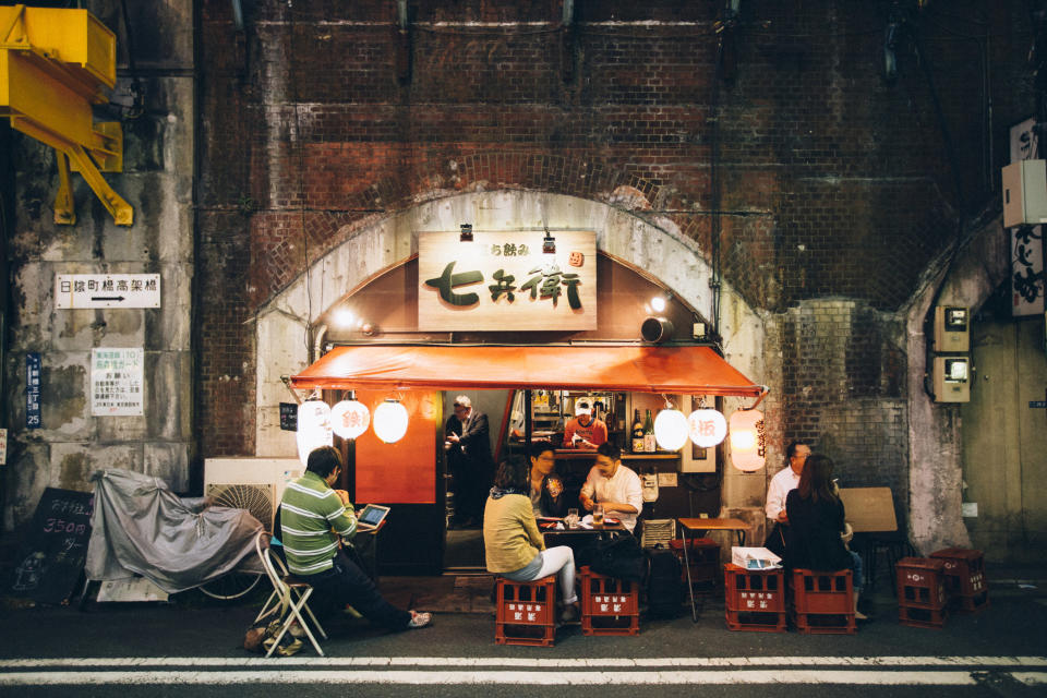 People eating at a small Japanese restaurant in Shinbashi district in Tokyo, famous for its night life.