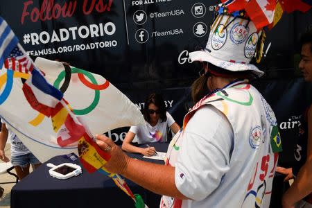 Jul 23, 2016; Los Angeles, CA, USA; American swimmer Janet Evans signs an autograph for Vivian Robinson at the Team USA Road to Rio tour at Venice Beach. Mandatory Credit: Kelvin Kuo-USA TODAY Sports