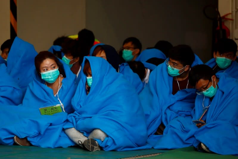 Protesters wait to receive medical attention after leaving the Hong Kong Polytechnic University campus, in Hong Kong