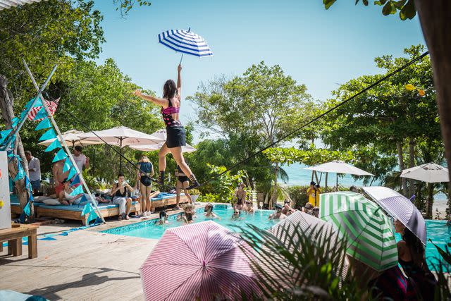 <p>Courtesy of Blue Apple Beach</p> Guests watch a tightrope performance over the pool at Blue Apple Beach