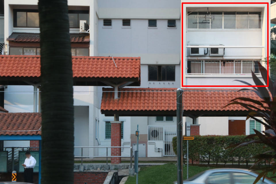 A suspected “customer” (in white) seen waiting at the bus stop close to the Hougang maisonette unit (red box) on 5 October. (PHOTO: Dhany Osman / Yahoo News Singapore)