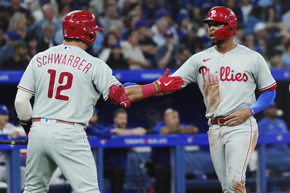 Philadelphia Phillies' Edmundo Sosa, right, celebrates with Kyle Schwarber after scoring against the Toronto Blue Jays during the sixth inning of a baseball game in Toronto, Tuesday, Aug. 15, 2023. (Nathan Denette/The Canadian Press via AP)